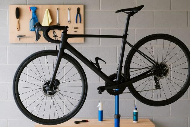 Racefiets op een onderhoudsstandaard in garage met gereedschap